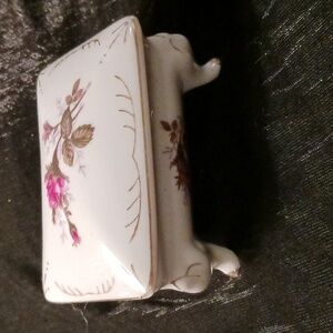 Old white painted porcelain jewelry box with four legs, gold trim